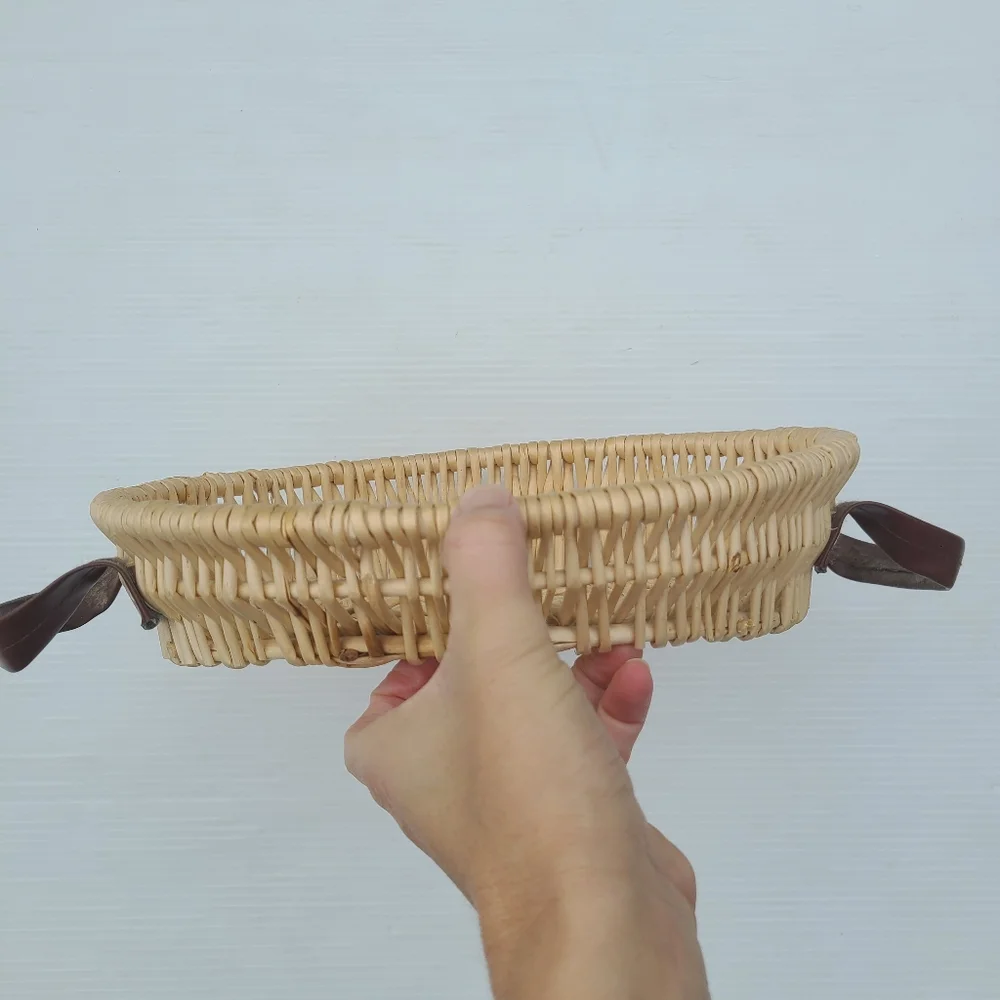 Woven wicker basket with faux leather handles
